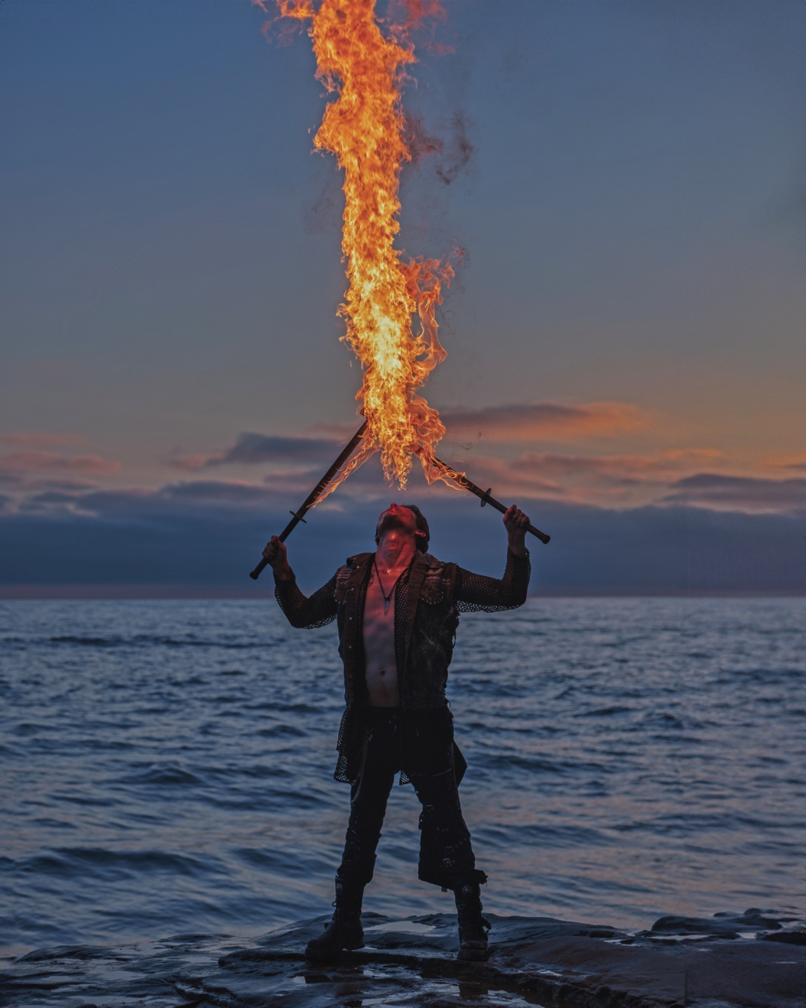Fire dancer at ocean sunset